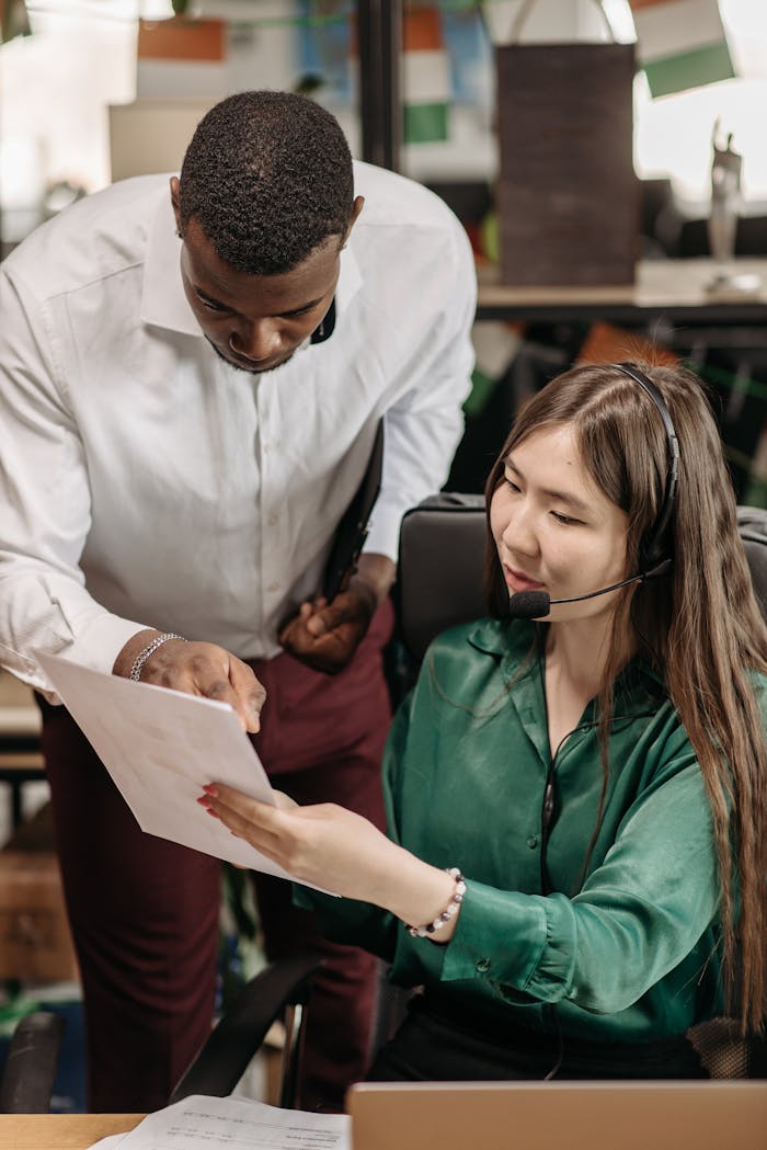 Two colleagues discussing a document in a modern office, reflecting teamwork and communication.