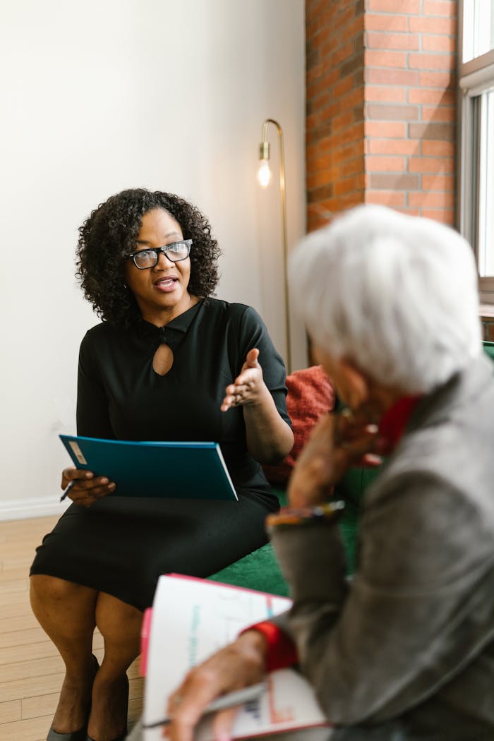 Two women engaged in a professional meeting, discussing business in a modern office setting.
